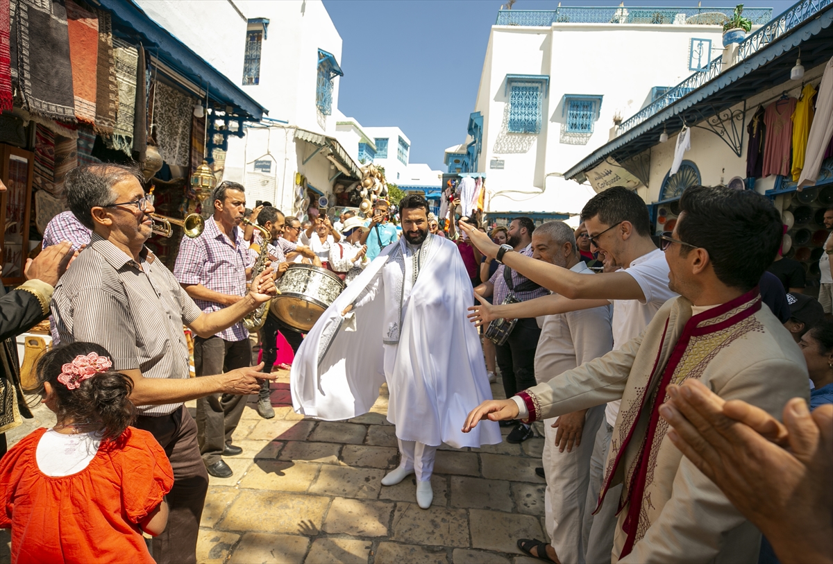 Düğünden bir gün önce yapılan törende, geleneksel beyaz renkli kıyafetler giyen damat Moez Souissi, hamamdan çıktıktan sonra müzik ve danslar eşliğinde aile evine yürüyor. 